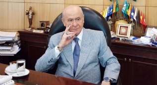 Bahçeli, yeni giydiği takım elbise ile makamında poz verdi